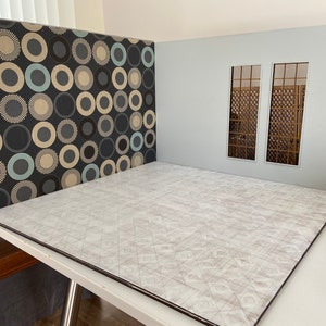May include: A dollhouse room set with a patterned wall, two windows, and a white tiled floor.