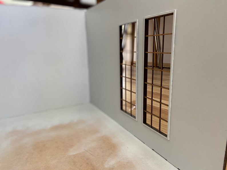 May include: A white room with two windows. The windows have a grid pattern and are framed in white. The floor is a light brown color.