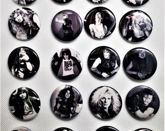 May include: A collection of 16 black and white button badges featuring various musicians. The badges are arranged in a grid pattern on a white background.