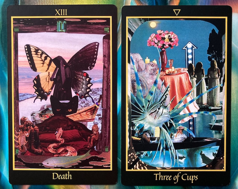 Pu&ograve; includere: Due carte dei tarocchi, Morte e Tre di Coppe. La carta della Morte presenta un gatto nero con una farfalla sopra, una barca e un serpente. La carta del Tre di Coppe presenta tre donne con abiti bianchi, un tavolo con una tovaglia rossa e un pesce con pinne blu e verdi.