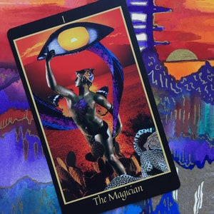 On the Magician card from the Telezma Tarot, the figure of Mercury points upwards towards the sun emerging from clouds encompassed by an eye. He has a breastplate of hummingbird feathers and stands among prickly pear cacti near wild cheetahs.