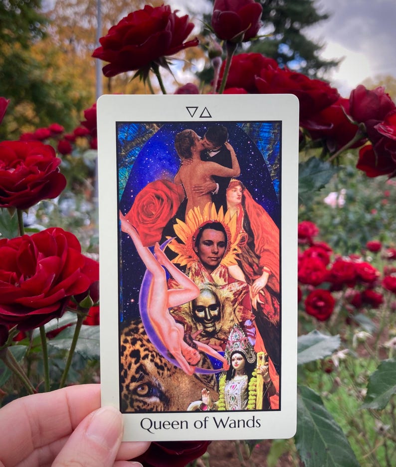 May include: A tarot card titled "Queen of Wands" features a collage of images including a couple kissing, a woman falling, and a deity. The card has a white border and is held in front of a background of red roses.