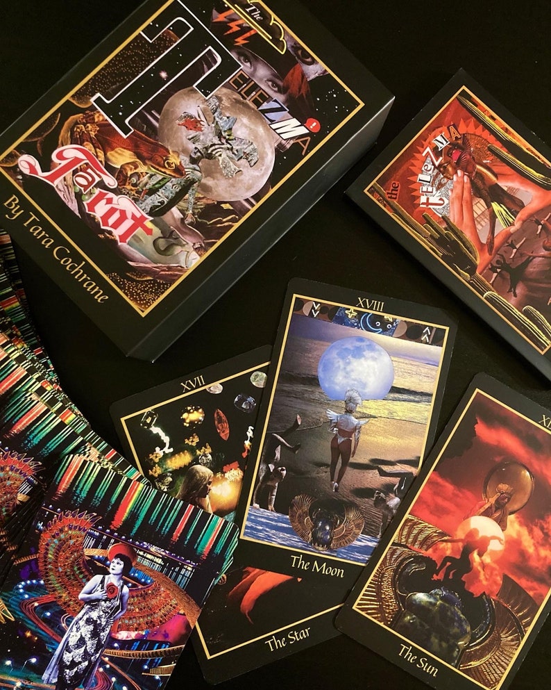 The Star, Moon and Sun cards from the Telezma Tarot with the card backs, magnetic flip box and booklet on a black background.