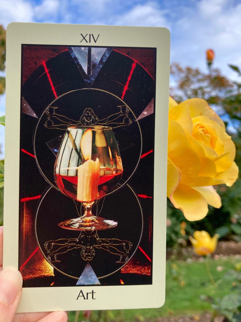 May include: A tarot card with the Roman numeral XIV at the top and the word "Art" at the bottom. The card features a wine glass with a candle inside, set against a dark background with geometric shapes and a human figure.