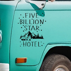 Puede incluir: Una furgoneta vintage azul turquesa con una pegatina de vinilo negro que dice "Five Billion Star Hotel" con una silueta de una caravana, montañas y árboles.
