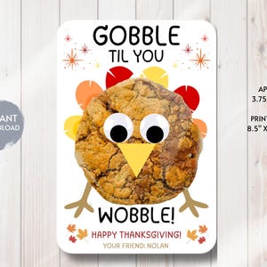 Puede incluir: Tarjeta imprimible con temática de Acción de Gracias con una galleta diseñada como un pavo. La tarjeta tiene el texto "GOBBLE TIL YOU WOBBLE!" y "HAPPY THANKSGIVING!" con el nombre "NOLAN". La tarjeta mide aproximadamente 9,5 cm x 14 cm.