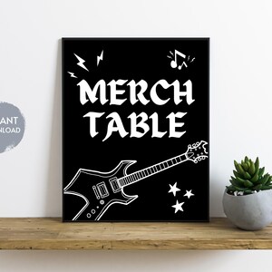 May include: Black and white graphic design with the text "Merch Table" and a stylized electric guitar.