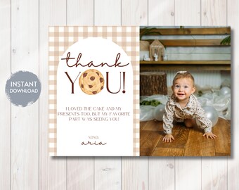 May include: A thank you card with a brown gingham background. The card has a brown circle with a chocolate chip cookie and the text "thank YOU!" in brown. The text "I loved the cake and my presents too, but my favorite part was seeing you!" is in brown. The text "NONO aria" is in brown. A photo of a baby girl crawling on a wooden floor is on the right side of the card.
