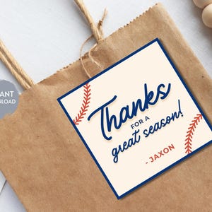 Könnte beinhalten: Eine braune Papiertüte mit einem Etikett mit der Aufschrift "Thanks for a great season!" in blauer Schrift. Das Etikett hat Baseball-Nähte und den Namen "Jaxon" in Rot. Ein "Instant Download" Aufkleber ist sichtbar.