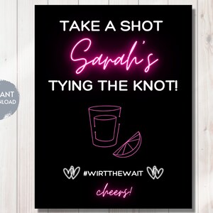 May include: A black and white sign with pink neon text that reads "Take a shot Sandi's Tying the Knot!" with a shot glass and lime wedge graphic. The hashtag #Wirtthewait and the word "cheers!" are also in pink neon text.