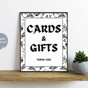 May include: Black and white printable sign with a decorative border of hearts, wings, and musical notes. The sign reads "Cards & Gifts Thank You!"