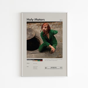 Może przedstawiać: Oprawiony plakat filmowy do filmu "Holy Motors" (2012) przedstawia mężczyznę w zielonym garniturze obok włazu. Plakat zawiera tytuł filmu, rok, reżysera, scenarzystów, gwiazdy i klasyfikację wiekową.