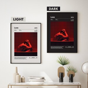 K&ouml;nnte beinhalten: Zwei Filmplakate f&uuml;r den Film "Love" aus dem Jahr 2015. Die Poster sind in schwarzen Rahmen und zeigen eine Person in einer Badewanne. Das Poster links hat einen hellen Hintergrund und das Poster rechts einen dunklen Hintergrund.