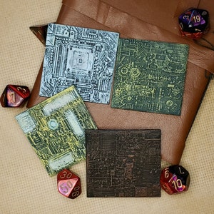 May include: Four square, printed circuit board coasters with a brown leather notebook and dice. The coasters are printed with a circuit board design in blue, green, yellow, and brown.