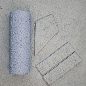 May include: A gray patterned rolling pin and four gray patterned tiles. The tiles are arranged in a diamond shape.