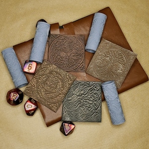 May include: A brown leather pouch with five grey fabric tubes and five red dice. The pouch has four decorative panels with intricate designs of a tree, a wolf, a dragon, and a snake.