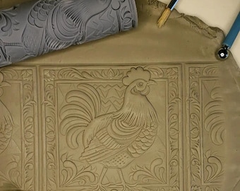 Peut inclure: Gros plan sur une surface en argile avec un motif de coq imprimé à l'aide d'un rouleau à pâtisserie. Le motif présente des détails complexes et une bordure décorative.