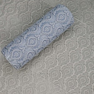 May include: A blue and white patterned rolling pin for baking. The rolling pin has a detailed design of repeating geometric shapes.