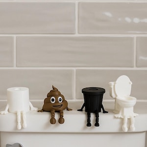 Könnte beinhalten: Eine skurrile Sammlung von Toilettenfiguren. Enthält eine weiße Toilettenpapierrolle, ein braunes lächelndes Kackhaufen-Emoji, einen schwarzen Mülleimer und eine weiße Toilette. Jede Figur hat Arme und Beine.