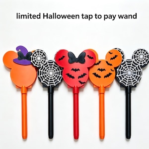 May include: Five limited Halloween tap to pay wands shaped like mouse heads. Designs include an orange head with a purple witch hat, a black spiderweb pattern, a red head with black bats, an orange head with black bats, and a black spiderweb.