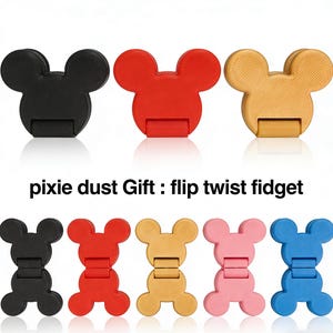 Peut inclure: Plusieurs jouets fidget en forme de souris, de couleurs noir, rouge et beige, avec le texte "pixie dust Gift : flip twist fidget" en dessous. D'autres jouets roses et bleus sont également affichés.