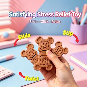 May include: A brown Mickey Mouse-shaped stress relief toy. The toy is made of several connected pieces that can be slid, clicked, and twisted. The image includes the text "Satisfying Stress Relief Toy" and "Slide • Click • Relax".
