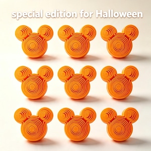 May include: Nine orange, circular, layered, mouse-shaped objects arranged in a grid. Each object features concentric rings forming a head and two ears. The text "special edition for Halloween" is printed in white at the top of the image.