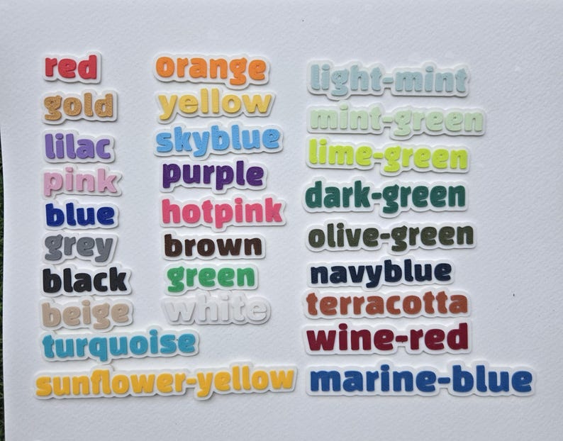 May include: A collection of colorful word stickers, each displaying a different color name. Colors include red, orange, yellow, green, blue, purple, and many more. The stickers have a white border.