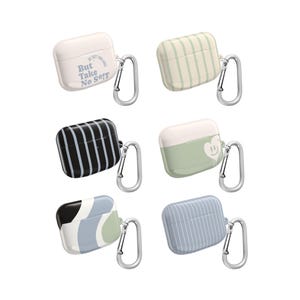 May include: Six AirPod cases in various designs. One is white with text, "But Take No S**t". Another has green and white stripes. Other cases have black and white stripes, a smiley face, and abstract designs. Each case has a silver carabiner.