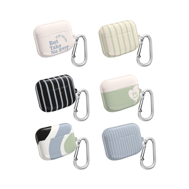May include: Six AirPod cases in various designs. One is white with text, "But Take No S**t". Another has green and white stripes. Other cases have black and white stripes, a smiley face, and abstract designs. Each case has a silver carabiner.