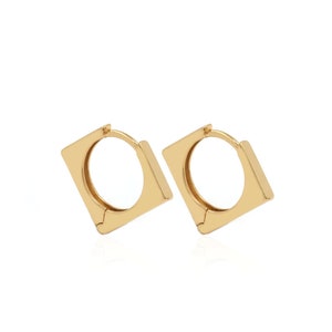 May include: A pair of gold square hoop earrings. The earrings are made of a smooth metal and have a simple, modern design.