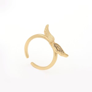 Op de afbeelding: Een goudkleurige ring met een uniek ontwerp. De ring heeft een gestileerde veer- of vleugelvorm met kleine, sprankelende accenten. Het open ontwerp maakt een verstelbare maat mogelijk.