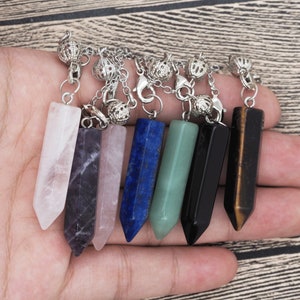 May include: Seven crystal point pendants on silver chains with ball connectors. The crystals are rose quartz, amethyst, clear quartz, lapis lazuli, aventurine, black onyx, and tiger's eye.