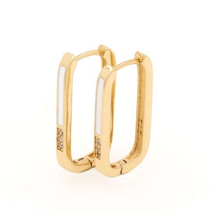 May include: Gold hoop earrings with a white enamel inlay and small clear stones.