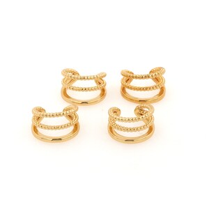 Puede incluir: Cuatro pendientes de aro dorados con un dise&ntilde;o de triple fila. Cada pendiente tiene tres filas de alambre peque&ntilde;o con cuentas.