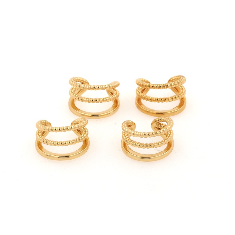 Puede incluir: Cuatro pendientes de aro dorados con un dise&ntilde;o de triple fila. Cada pendiente tiene tres filas de alambre peque&ntilde;o con cuentas.