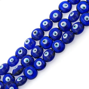 Può includere: Una collana di perline di vetro blu con disegni di occhi maligni bianchi. Le perline sono rotonde e hanno una finitura lucida.
