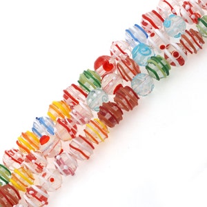 Può includere: Una collana di perline di vetro colorate con vari motivi, tra cui strisce, punti e spirali. Le perline sono traslucide e hanno una finitura lucida.