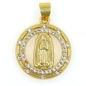 May include: Gold-tone pendant featuring a depiction of the Virgin Mary surrounded by clear cubic zirconia stones.