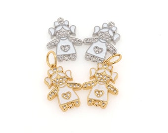 May include: Four charms in the shape of a girl with a heart on her dress. Two charms are gold and two are silver. All charms are decorated with clear rhinestones.