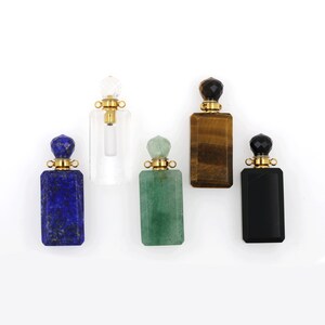 May include: Five gemstone perfume bottles with gold caps. The bottles are made of clear quartz, green aventurine, blue lapis lazuli, black obsidian, and tiger's eye.