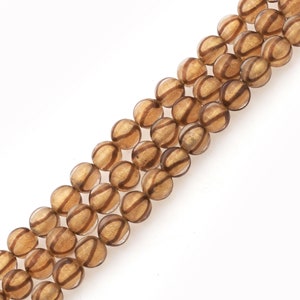 May include: A strand of brown glass beads with gold accents. The beads are round and have a striped pattern.