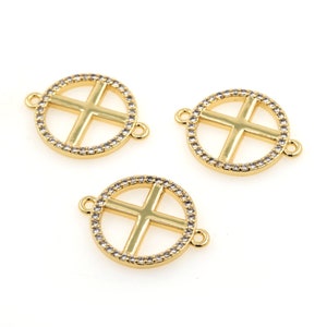 May include: Three gold-toned metal circle charms with a cross design. Each charm is embellished with clear rhinestones around the edge.