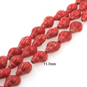Könnte beinhalten: Eine Strähne roter Keramikperlen mit einer strukturierten Oberfläche. Jede Perle ist etwa 11,7 mm groß.