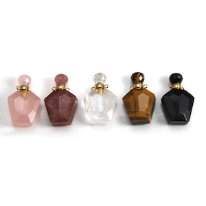 Peut inclure: Cinq petites bouteilles en verre en forme d'étoile avec des bouchons dorés. Les bouteilles sont faites de différents types de pierres précieuses : quartz rose, améthyste, quartz clair, œil de tigre et onyx noir.