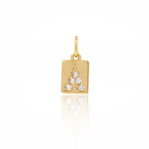 Puede incluir: Encanto de colgante de oro con forma cuadrada y la letra A engastada con pequeños diamantes transparentes.