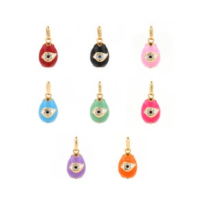 Könnte beinhalten: Satz von zehn goldfarbenen Anhängern in Form von Eiern mit einem bösen Auge. Die Eier sind in verschiedenen Farben, darunter Rot, Schwarz, Pink, Blau, Grün, Lila und Orange.