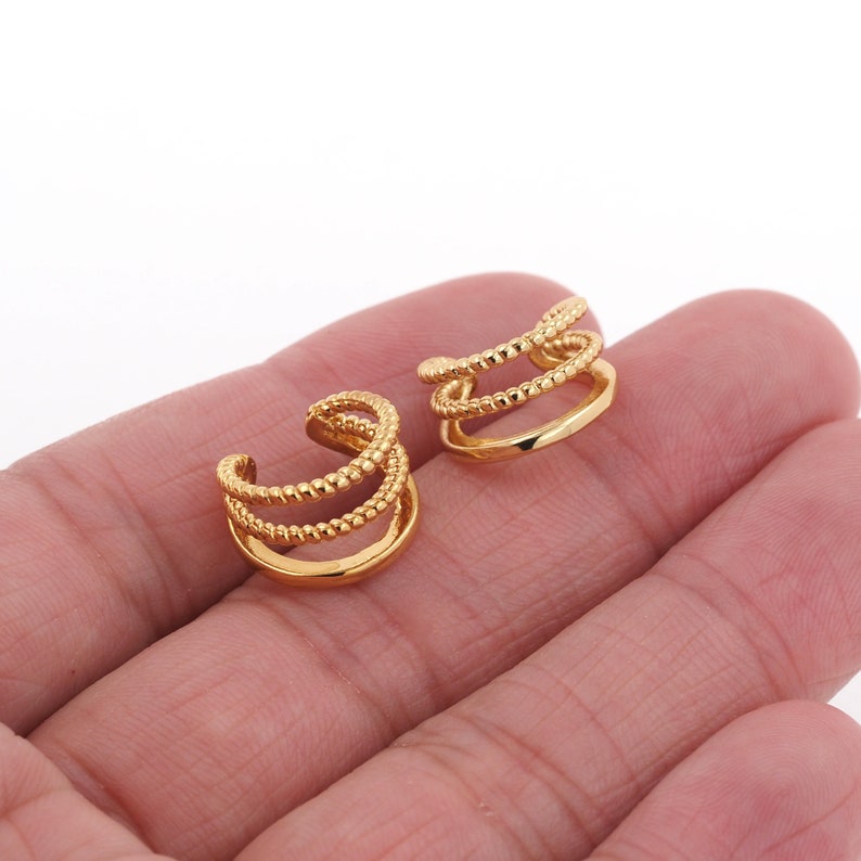 Puede incluir: Un par de pendientes de aro dorados con un dise&ntilde;o de tres capas. Cada aro presenta un detalle texturizado y con cuentas.