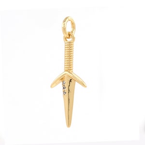 May include: A gold-toned dagger charm with three clear rhinestones on the blade.