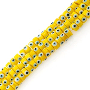 May include: A strand of yellow glass beads with blue and black evil eye designs.